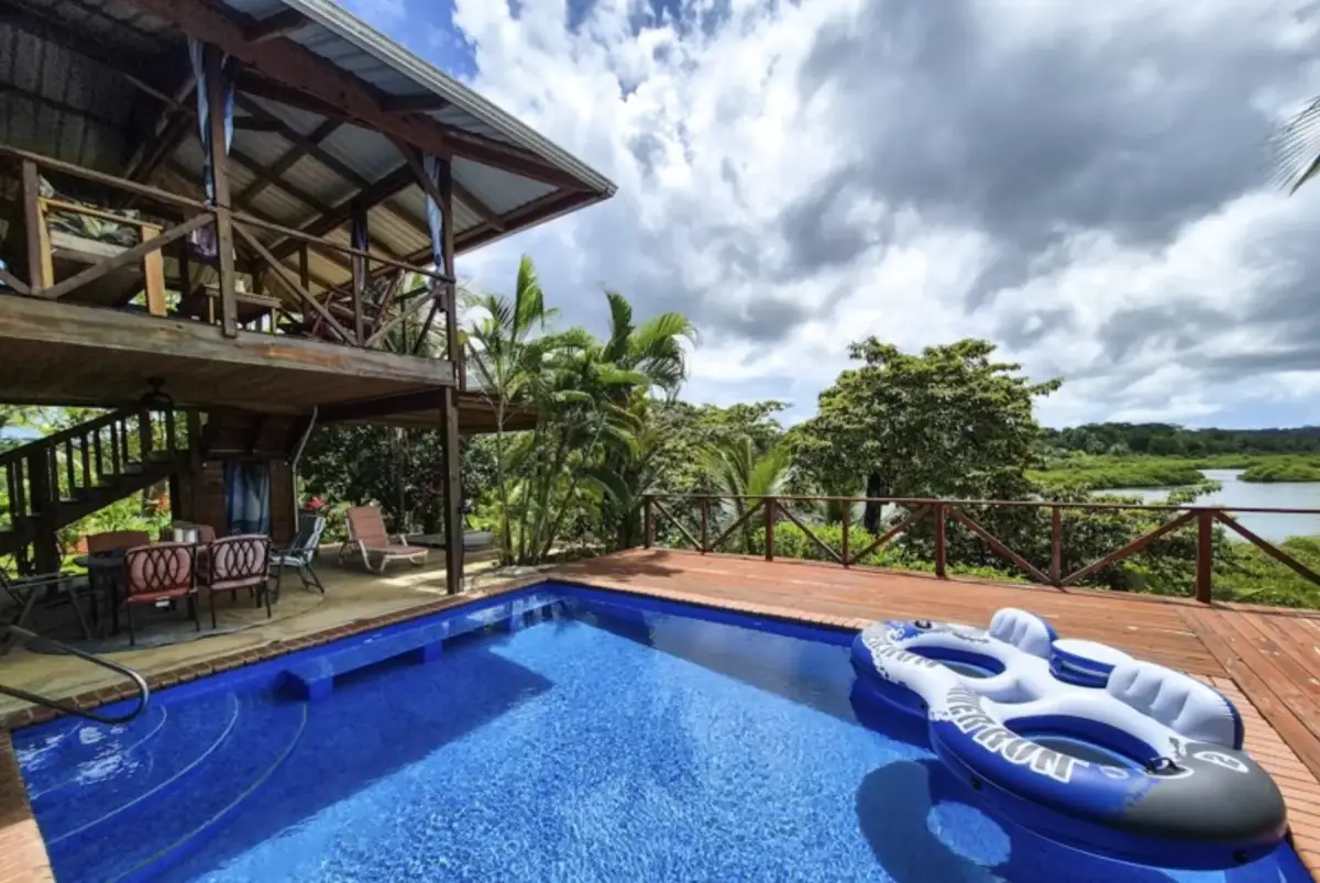 Pool deck with the house above, looking out over the channel